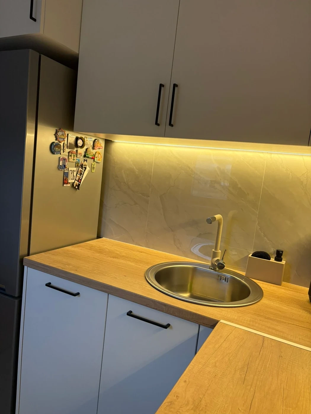 Detalj kuhinje po meri sa sudoperom, radnom pločom i kompaktnim ugaonim rešenjem