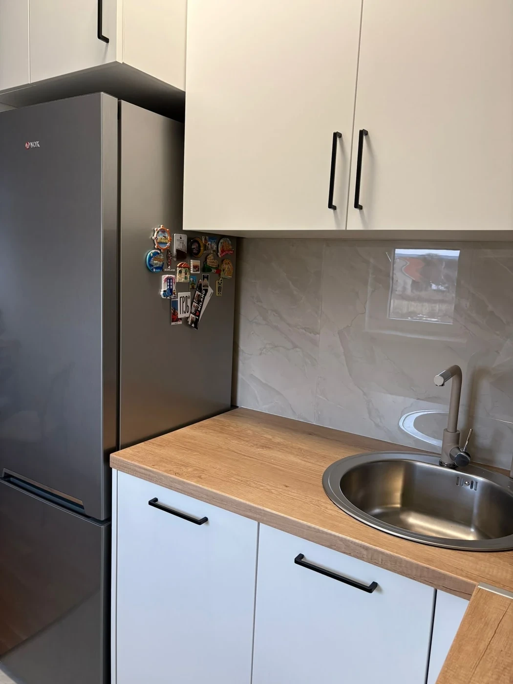 Detalj kuhinje po meri sa frižiderom, sudoperom i radnom površinom